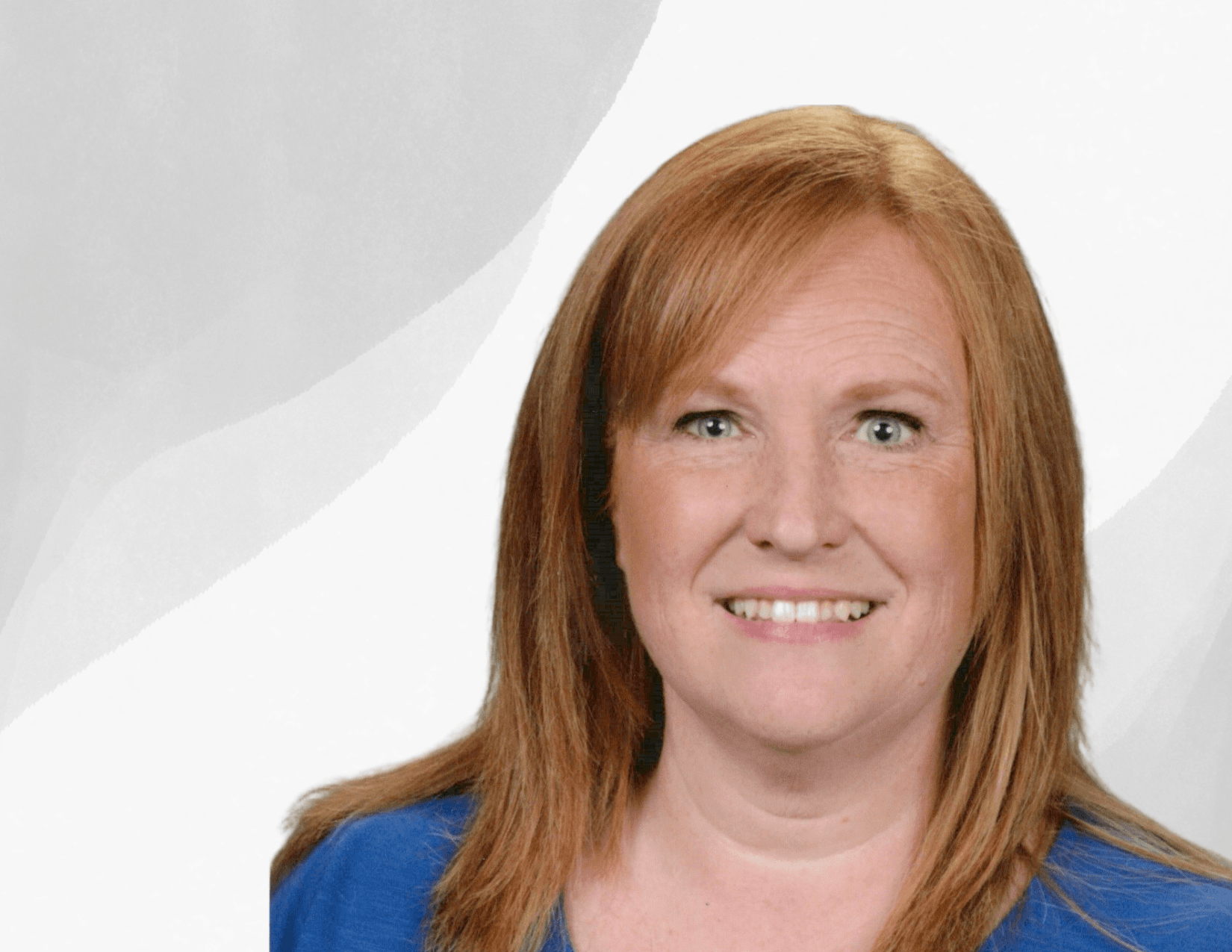 A woman with straight, shoulder-length red hair and blue eyes, smiling at the camera. She is wearing a blue top and is set against a light, abstract background.