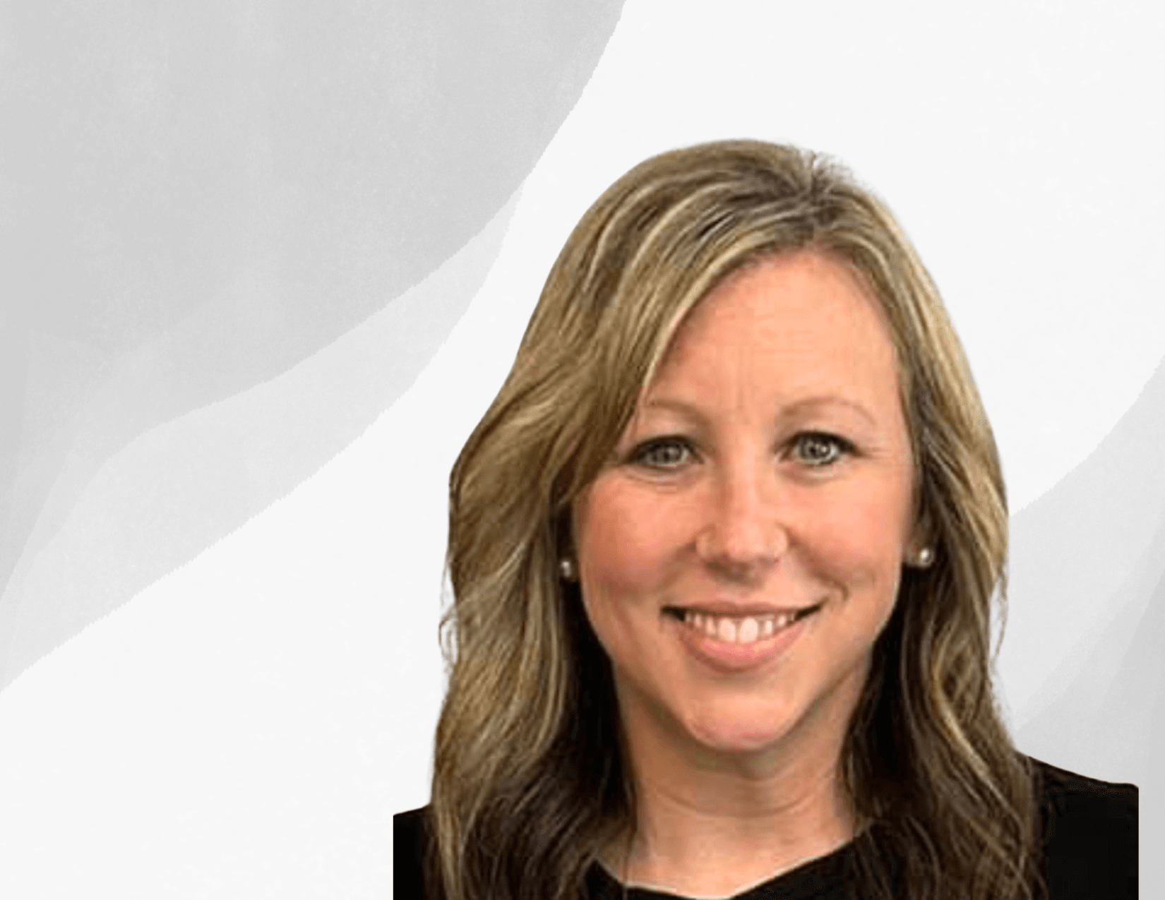 A woman with blonde, wavy hair and light eyes smiles at the camera. She is wearing a black top and is posed in front of a light, abstract background.