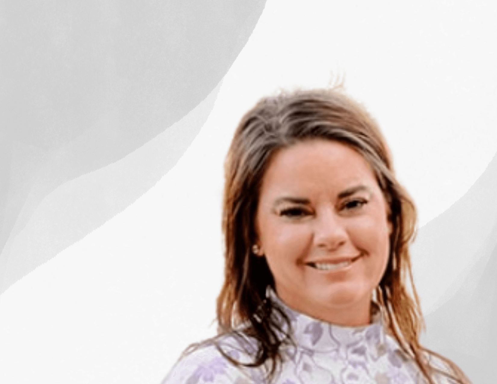 A woman with light brown hair and a floral high-neck top smiles in front of a light gray and white abstract background.
